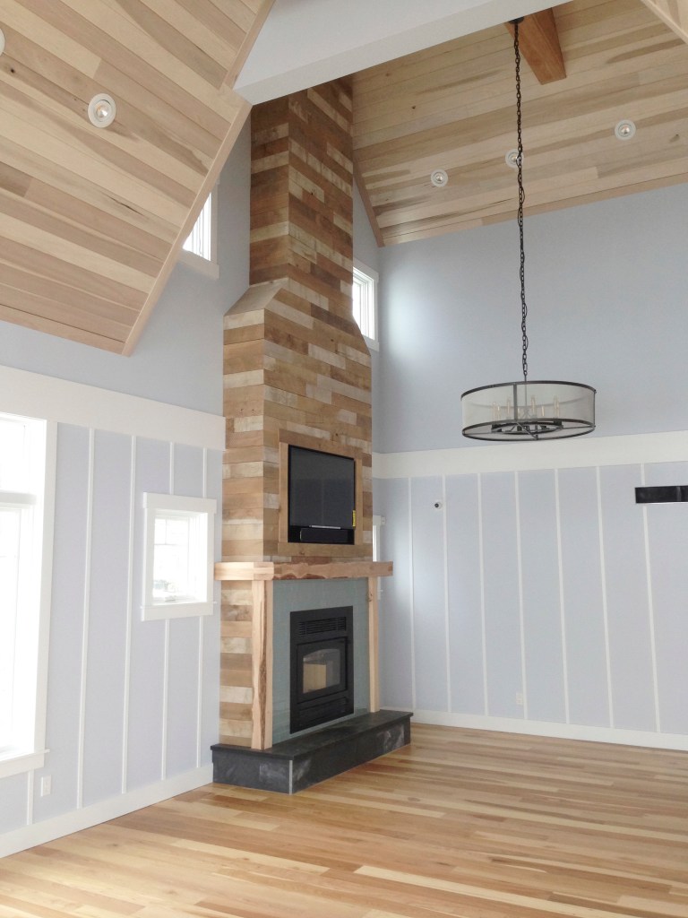 beach house high ceiling fireplace installation with hardwood floors