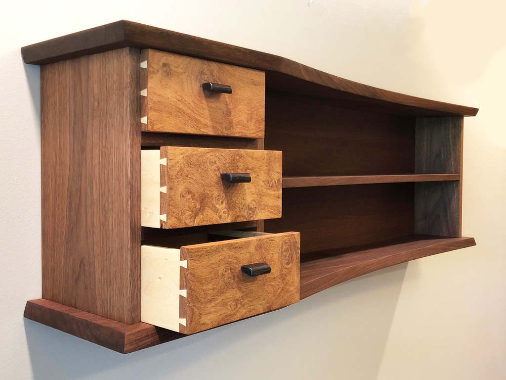 three drawers partially opened on walnut cabinet with three shelves at an angle